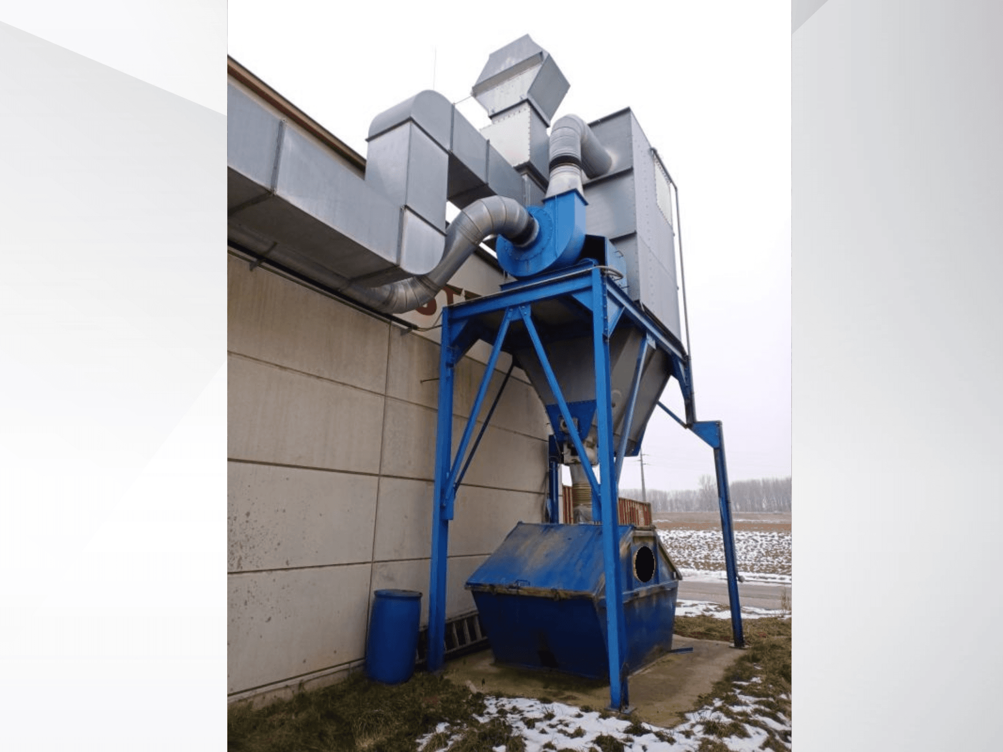 LBH suction system in blue with a cylindrical separator and connection pipes, front view against a snowy background.