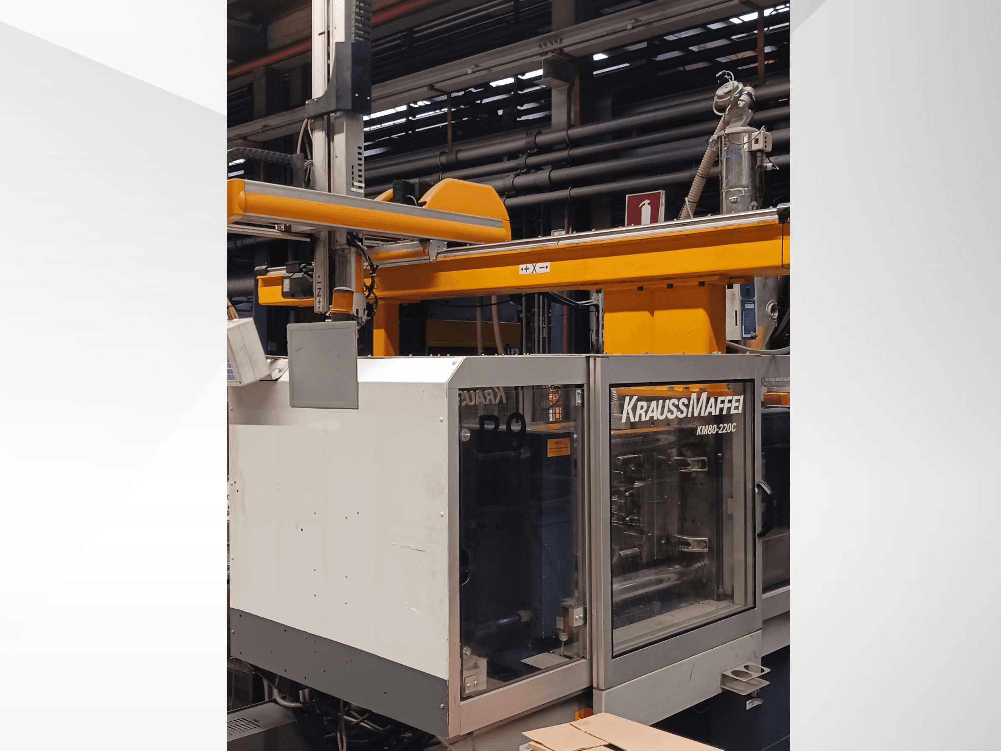 KraussMaffei KM80-220C injection molding machine in side view with yellow robotic arm and control panel visible.