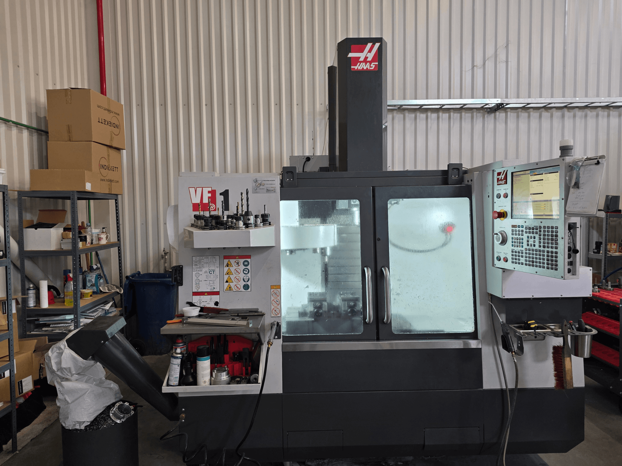 HAAS VF 1 Vertical Machining Centre in a workshop, front view showcasing control panel and milling area with tools.