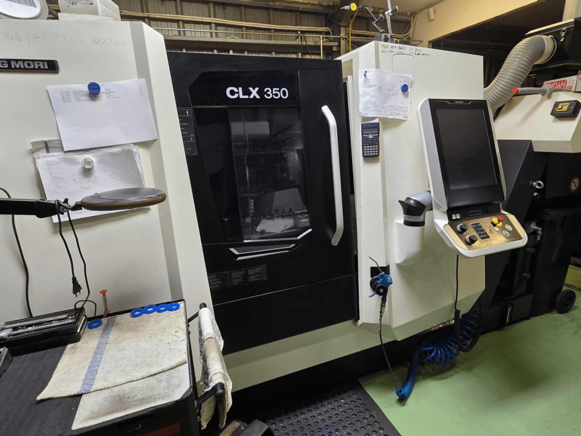 DMG MORI CLX 350 CNC lathe in a workshop; front view with control panel, tools, and workspace visible.