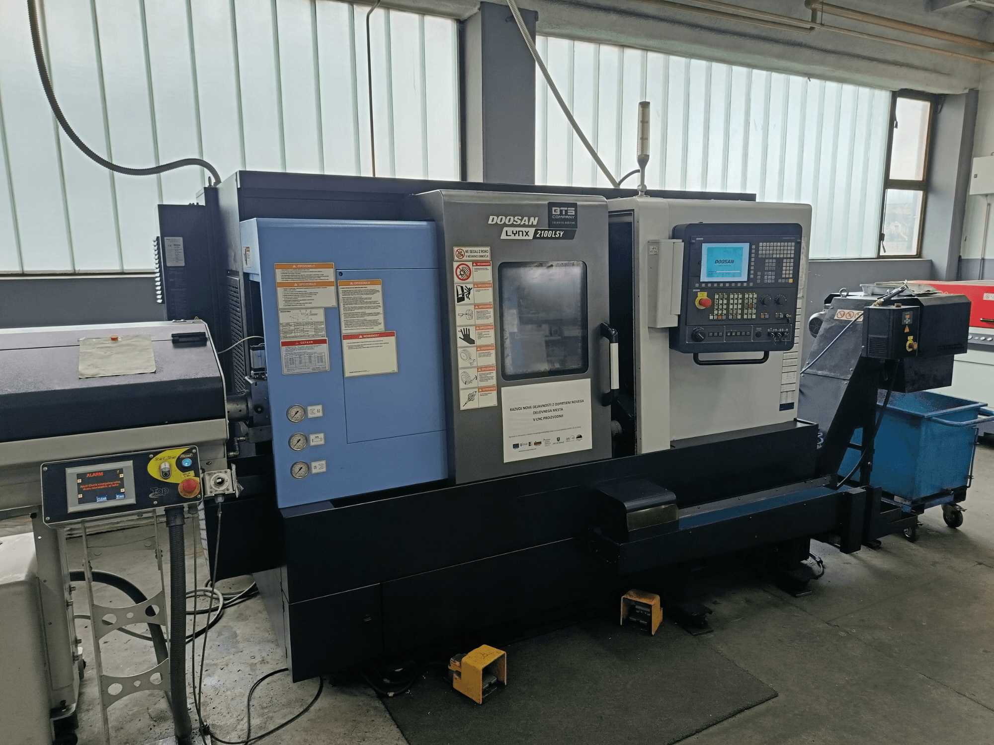 DOOSAN LYNX 2100 LSY Turn-Mill Centre, side view showing control panel and operational buttons, with informational labels visible.