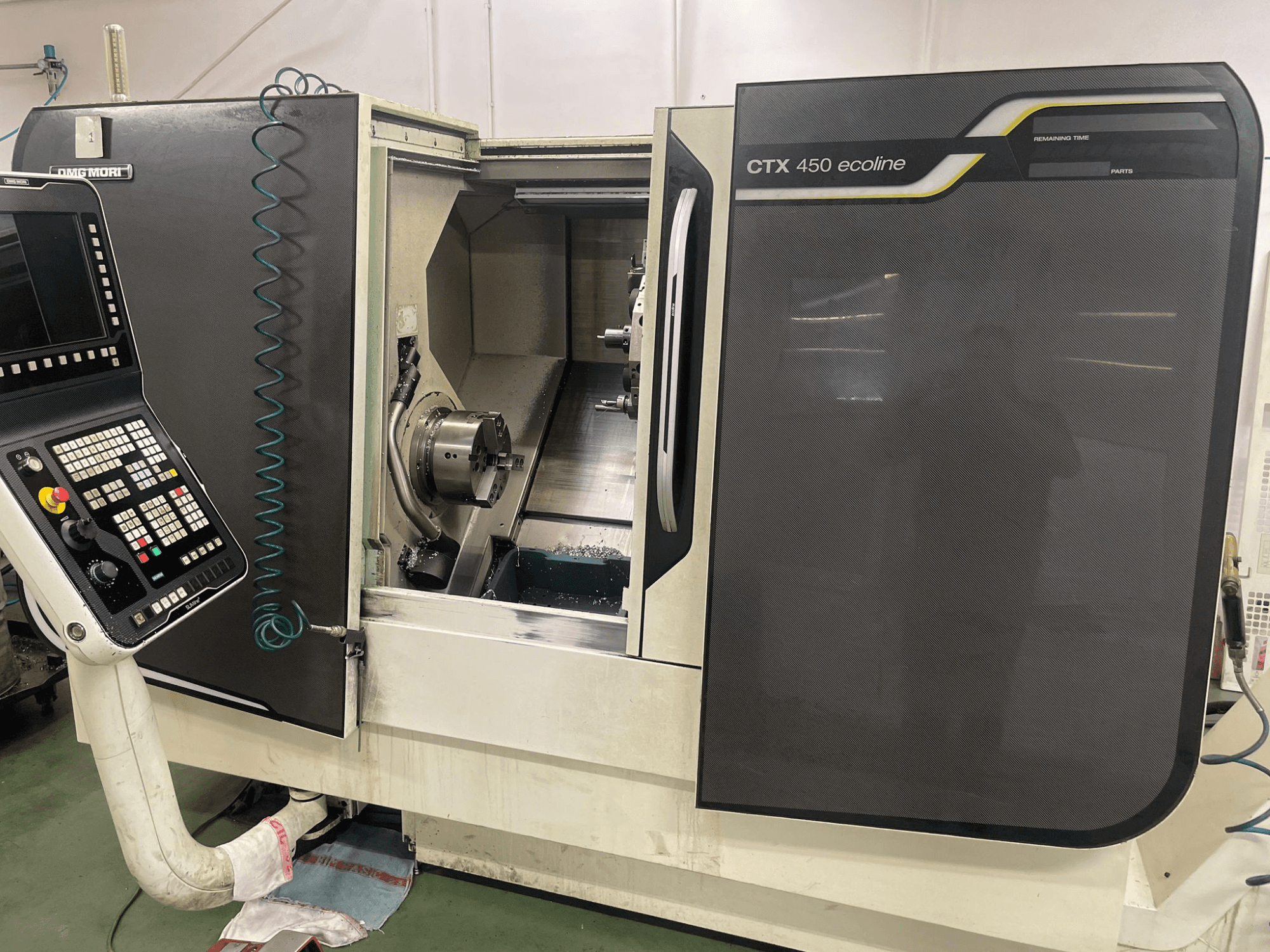 DMG MORI CTX 450 ecoline CNC machine in side view, displaying control panel, chuck, and machining area.