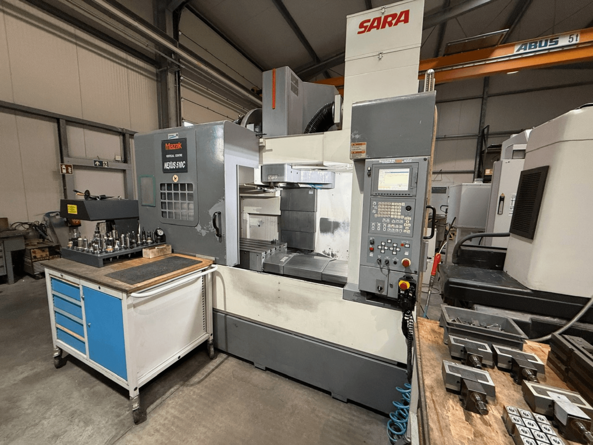 Mazak Nexus 510C vertical machining center, front view, with tools on a cart; SARA branding visible; technical controls shown.