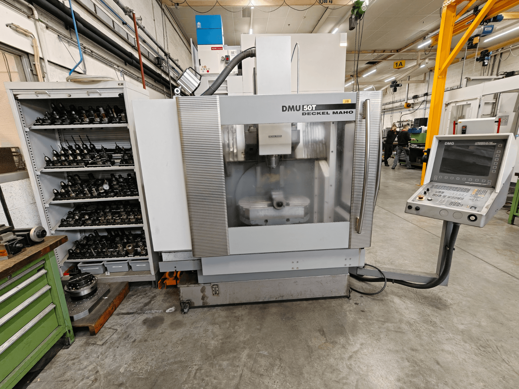Vertical machining center DECKEL MAHO DMU 50T from a front view, featuring a control panel and tool storage area.
