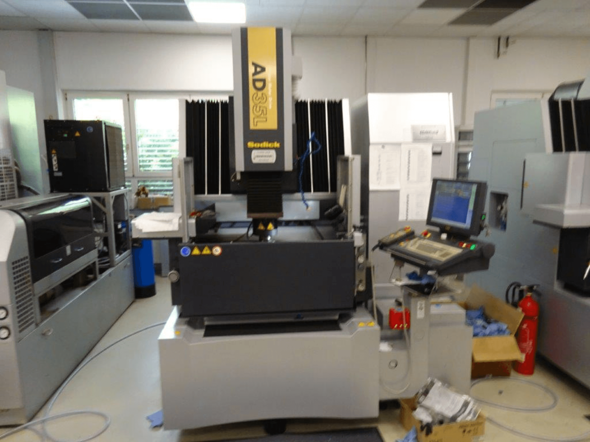 Sodick AD35L CNC machine from front view, featuring control panel, cooling unit, and safety indicators.