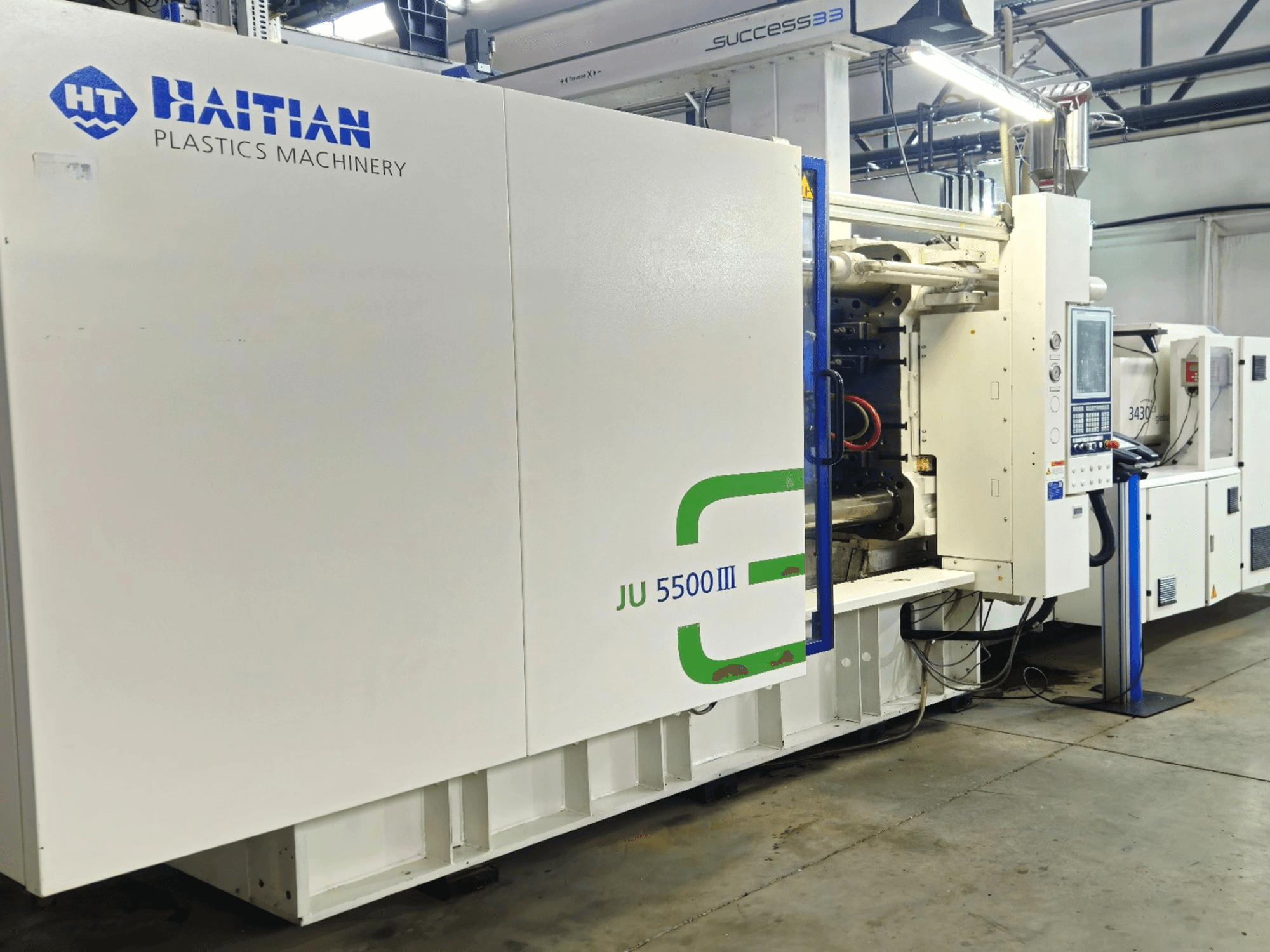 Haitian JU 5500III plastic machinery in a factory setting, front view showcasing control panel and production area.
