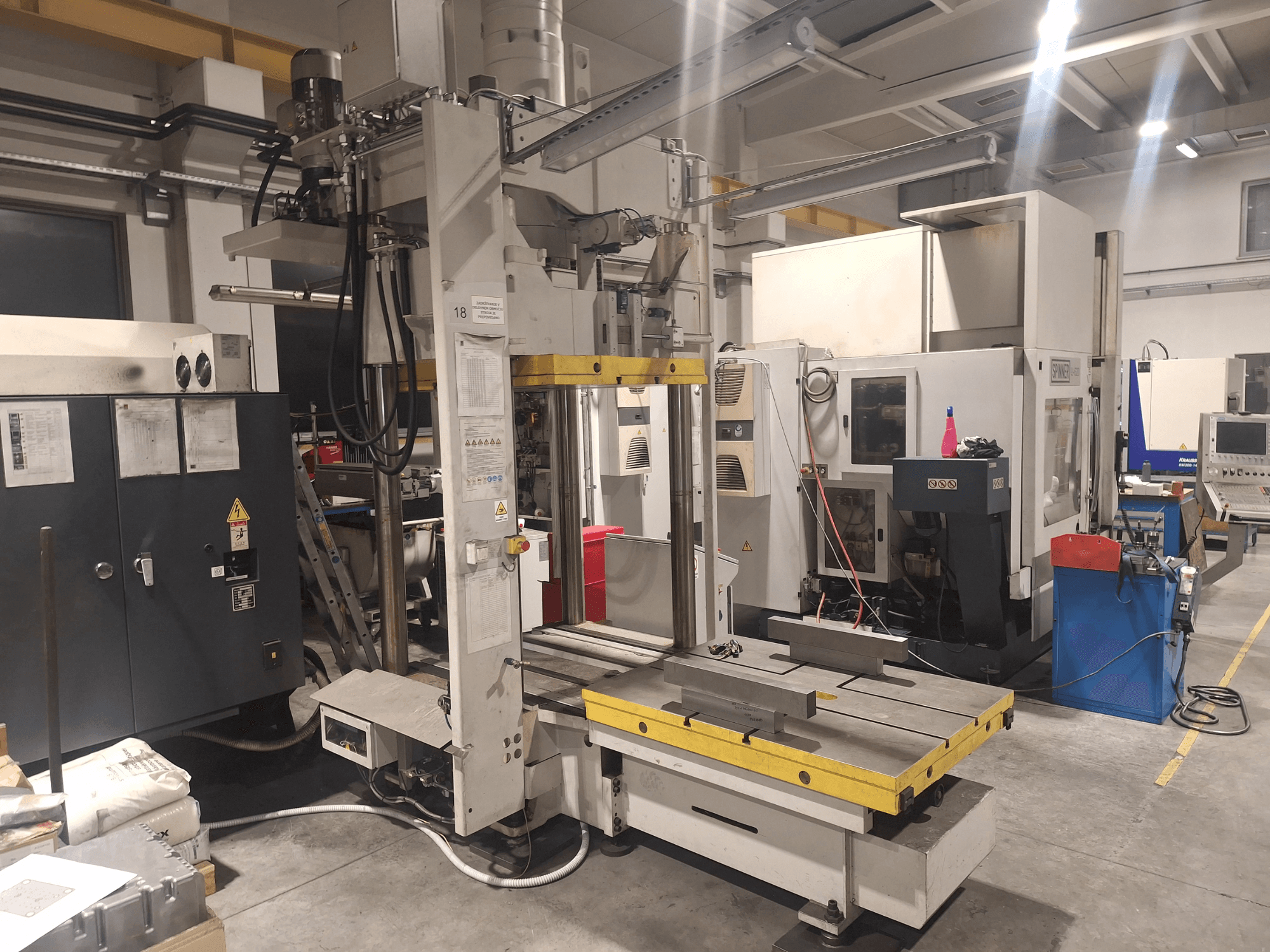 Horizontal milling machine by Synergic, front view; features a wide table and various control panels, in a workshop setting.