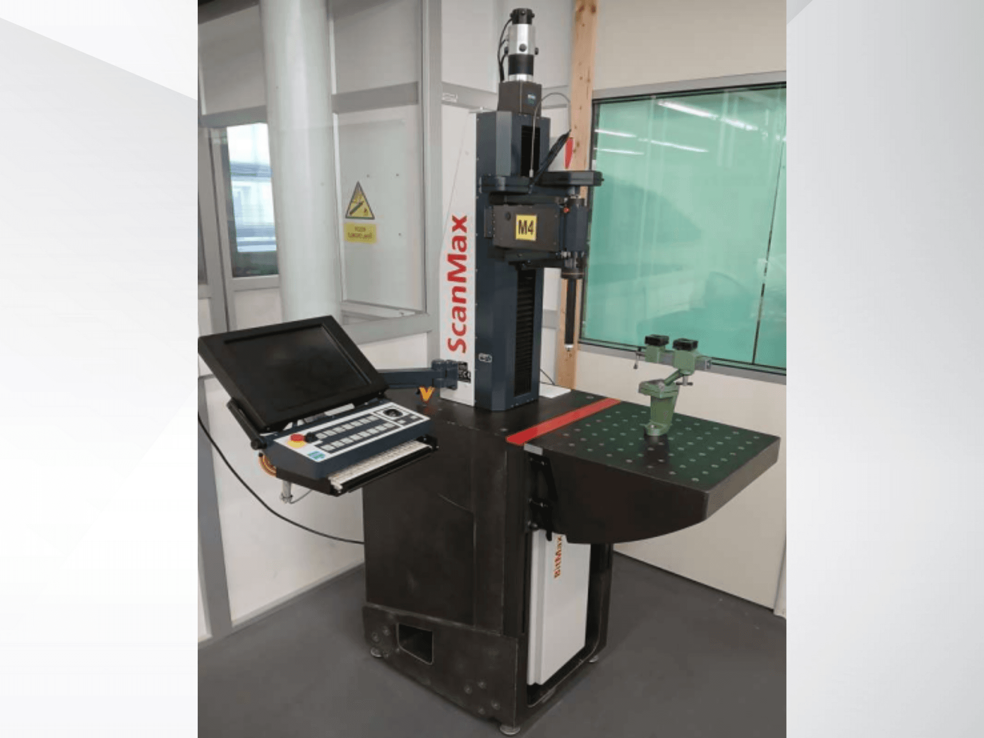 ScanMax M4 measurement machine, front view with control panel and green calibration fixture on a dotted work table.