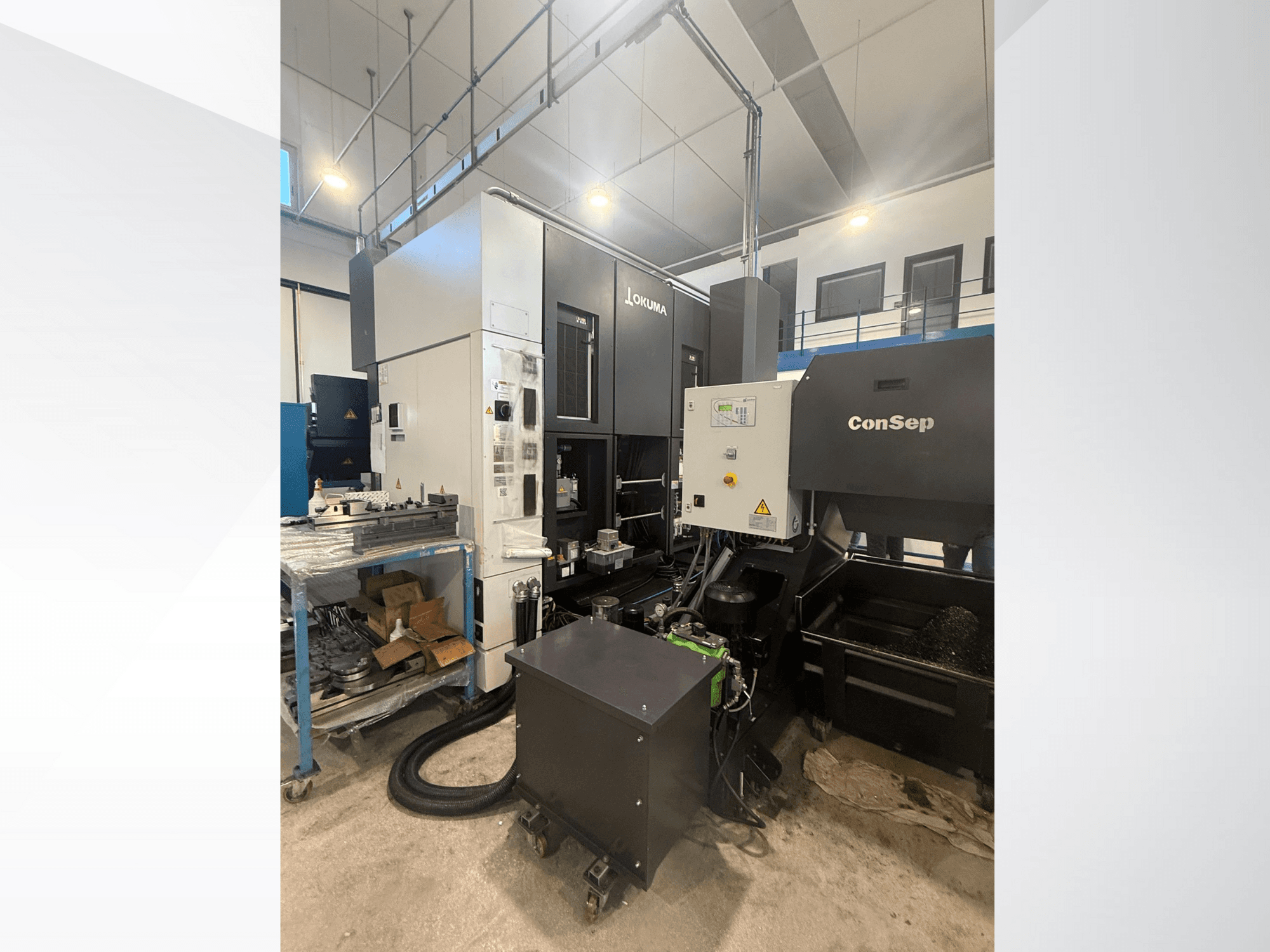 Okuma machining center with ConSep unit, side view, displaying controls and industrial setup, including metal chips bin.