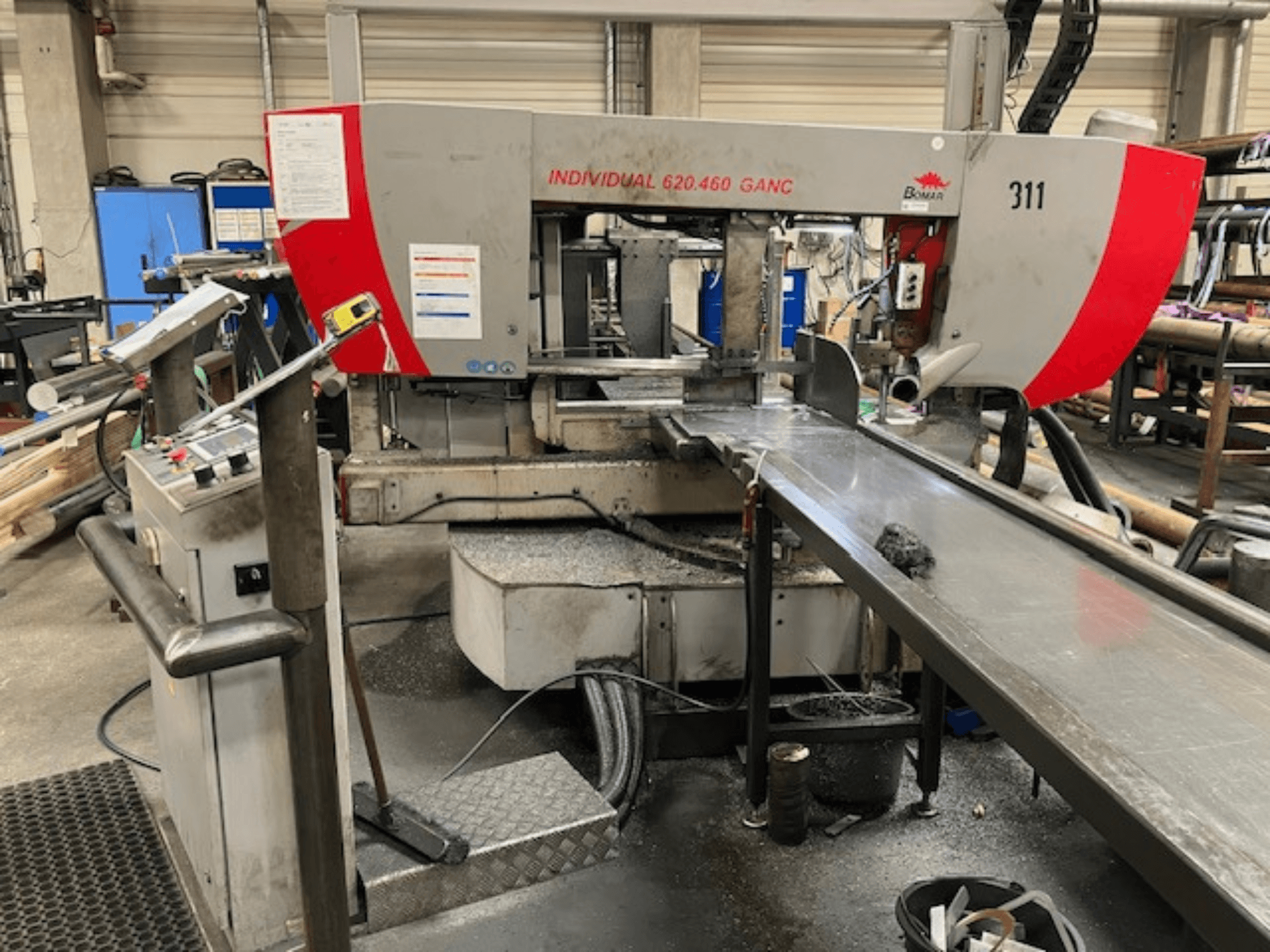 BOMAR INDIVIDUAL 620-460 GANC band saw, front view, showing controls, cutting area, and industrial workshop background.