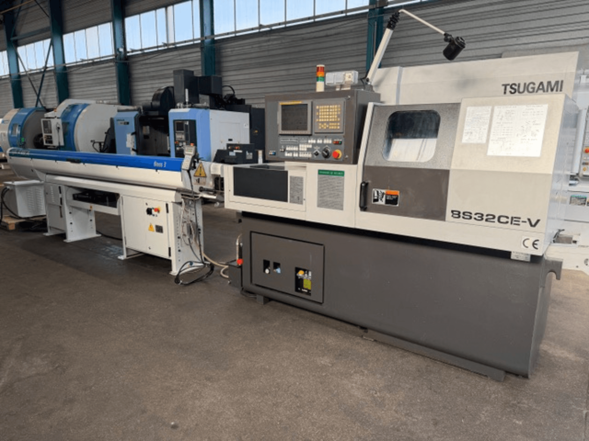 TSUGAMI BS32CE-V Swiss type turning machine in a front view, featuring a control panel and attached spindle.