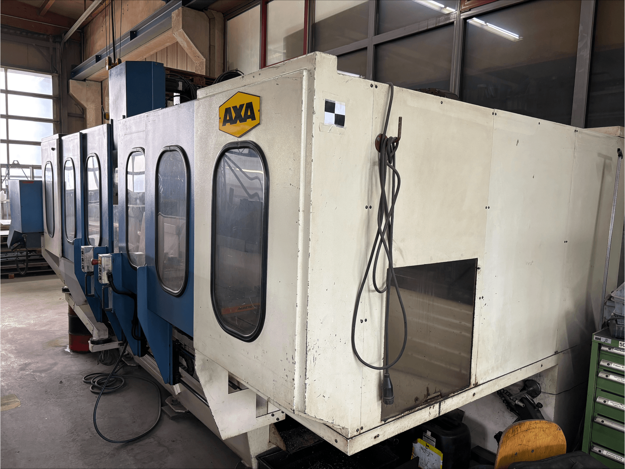 AXA VSC-1-M/C vertical machining center, front view, featuring a large white cabinet and blue control panel.