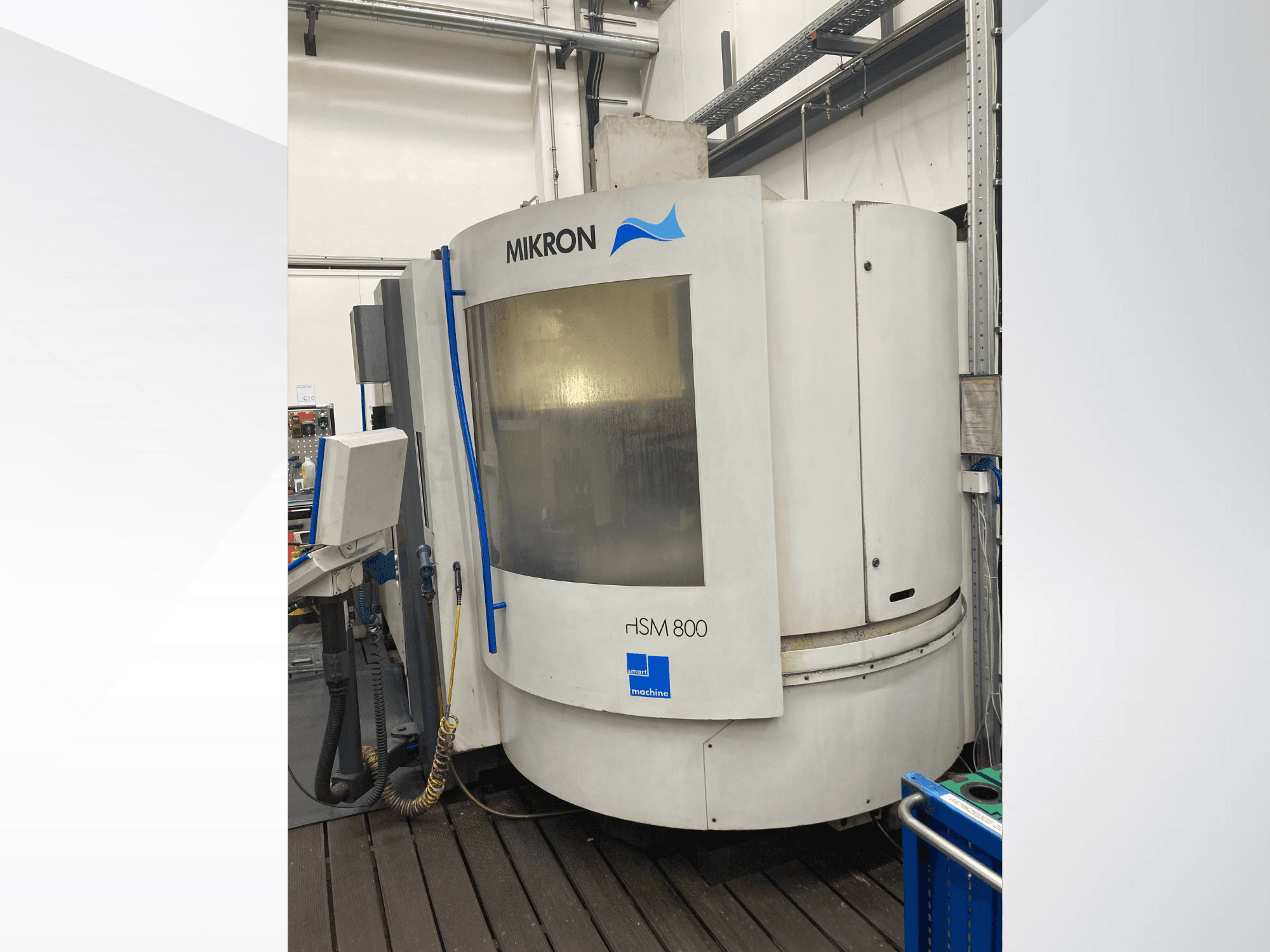 Mikron rISM 800 CNC machine, front view with control panel, cylindrical design and blue accents, set in a workshop environment.