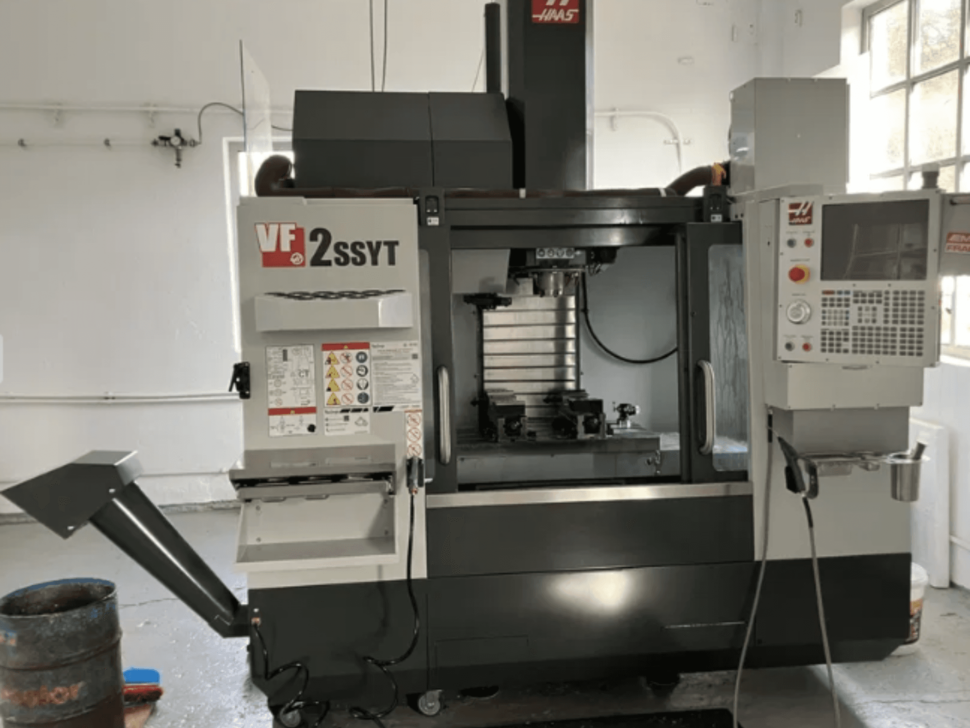 Haas VF-2SSYT CNC mill, front view, features control panel, tool holder, and coolant system for metal machining.