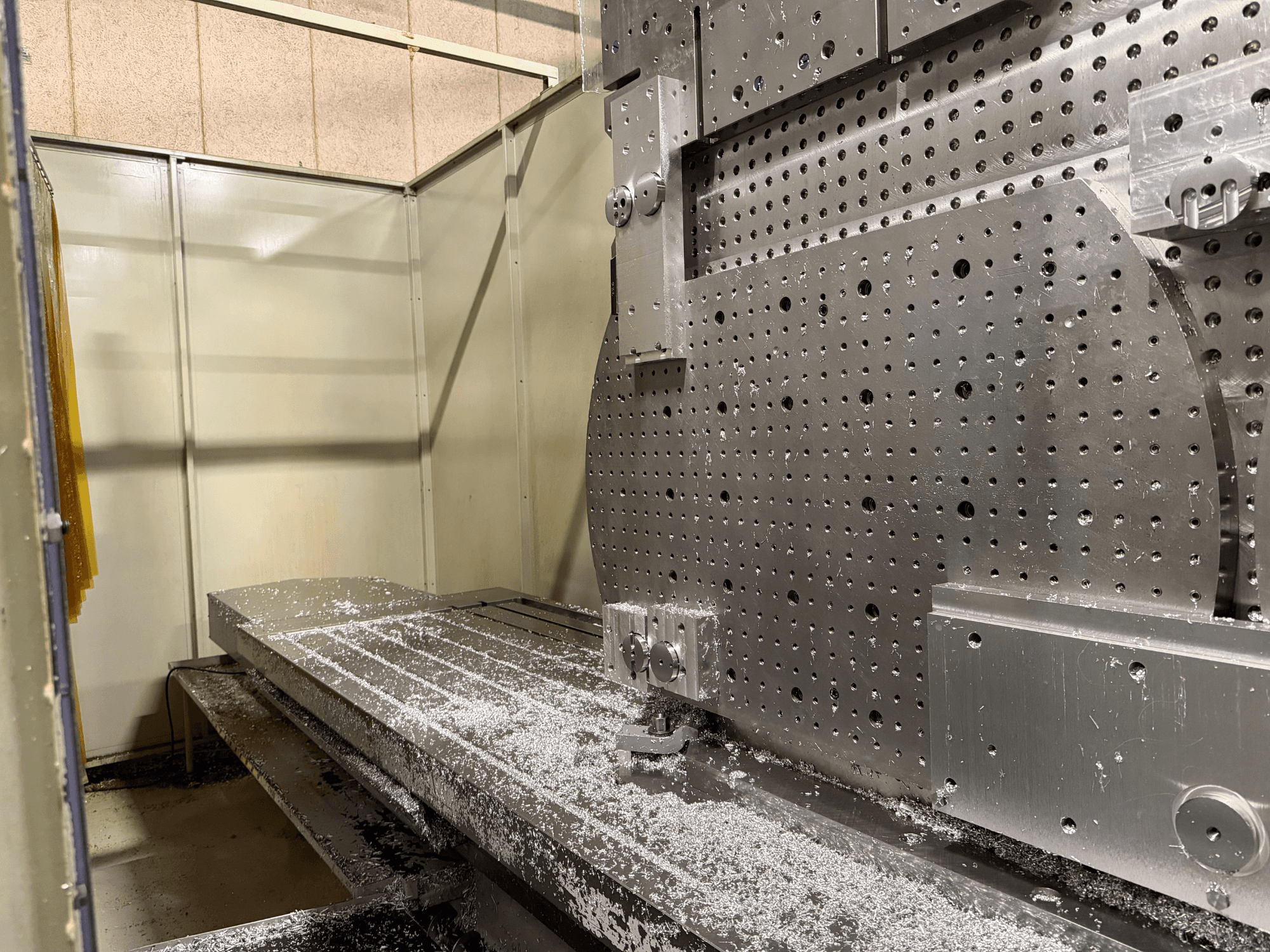 Close-up front view of the KIHEUNG KNC-U1000 Universal Machining Centre, showing a metal work table with aluminum shavings.